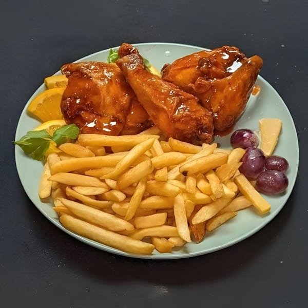 A plate of Charlie Staples Pitt Boss BBQ chicken wings with fries, orange slices, grapes, and cheese.